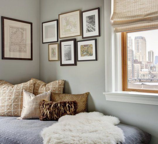 a bedroom with pictures on the wall and a bed in front of a window,