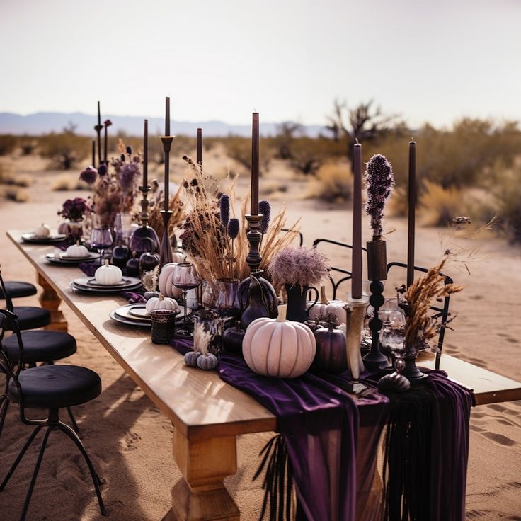 a long table is set up with purple and white decorations, candles, and pumpkins