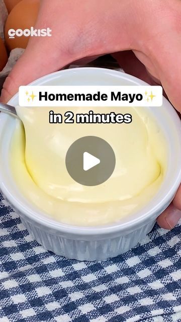 someone is dipping mayo into a bowl with an egg in the background and text that reads homemade mayo in 2 minutes