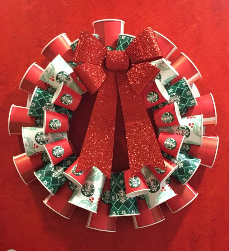 a christmas wreath made out of red and green wrapping paper with a bow on top