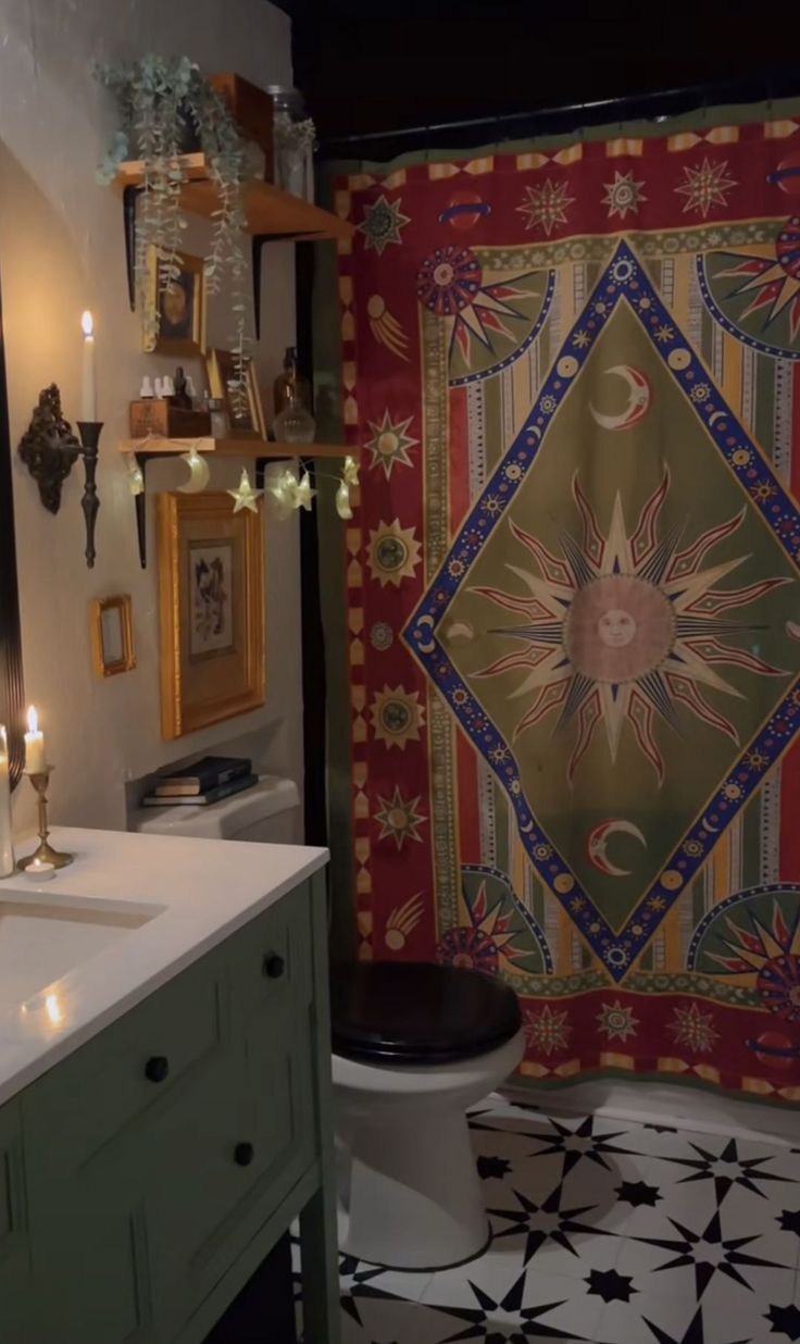 a bathroom with a large tapestry on the wall and black and white tile flooring