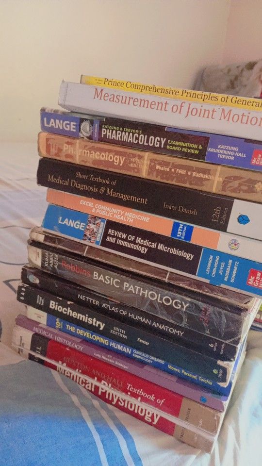 a stack of books sitting on top of a bed