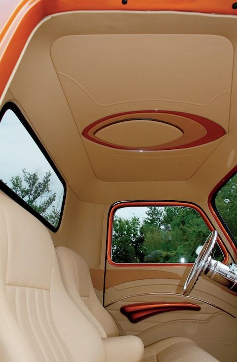 the interior of an old car with white leather seats and red trim on the dash