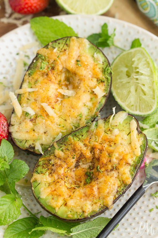 two stuffed eggplant halves on a plate with strawberries and limes