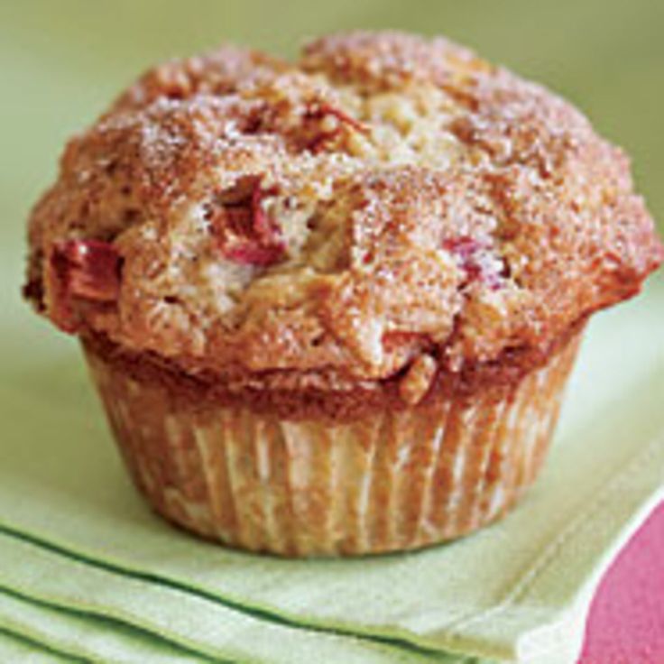 a muffin sitting on top of a green cloth next to a pink and white napkin