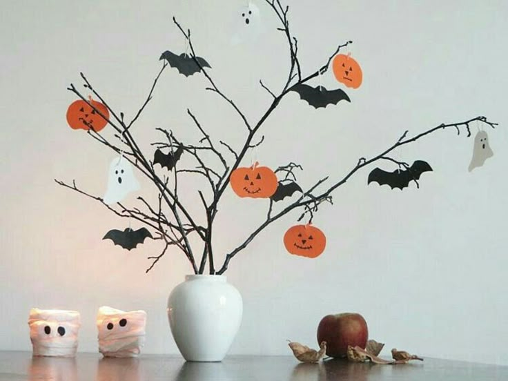 a white vase filled with halloween decorations on top of a table