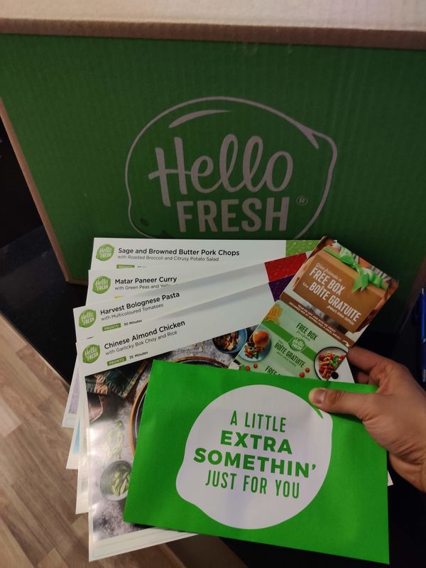 someone is holding up some food in a box with the words hello fresh written on it