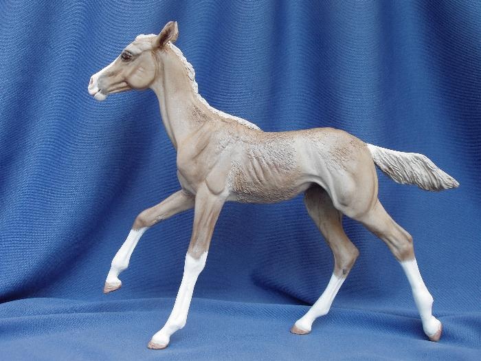 a toy horse is standing on a blue background