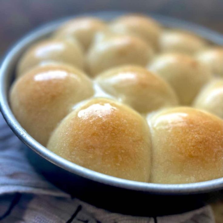 a pan filled with bread sitting on top of a table next to a cloth and napkin