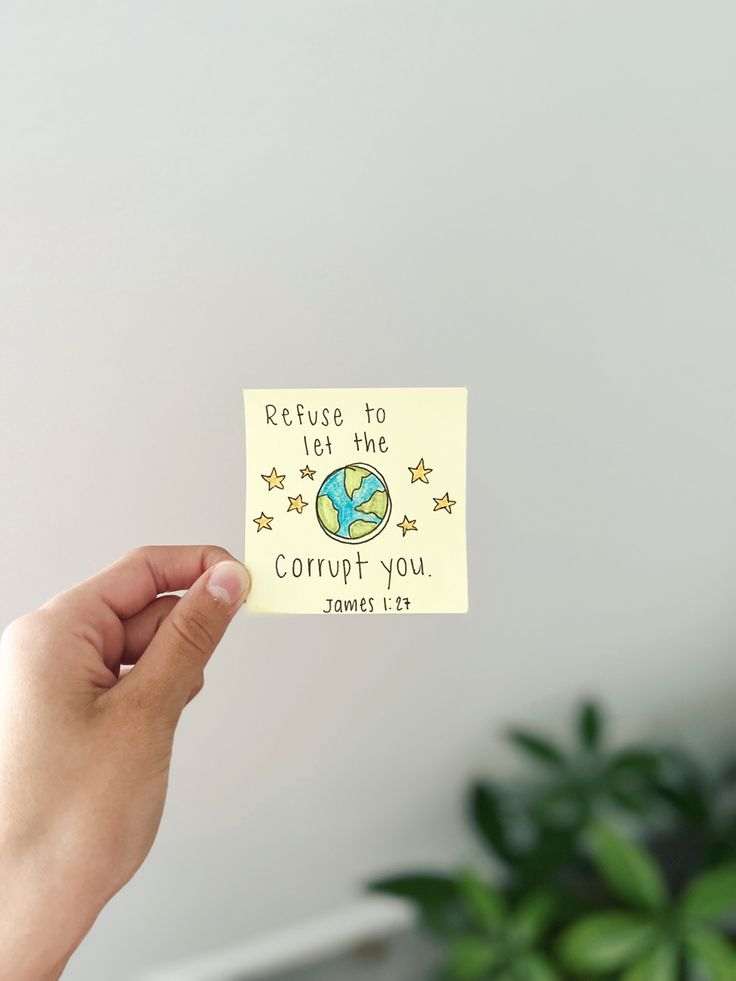 someone holding up a sticker with the words return to earth, and stars on it