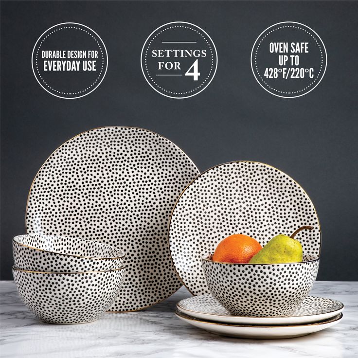 a white and black table setting with fruit in the bowl on it's side