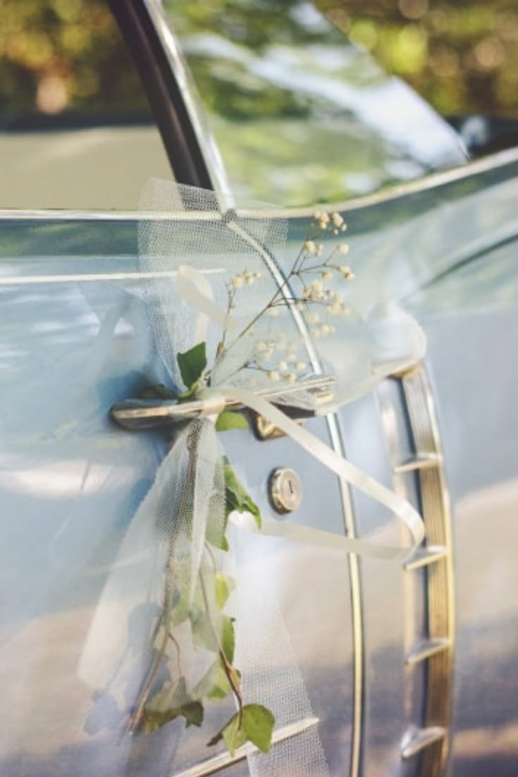 a car with flowers tied to it's side