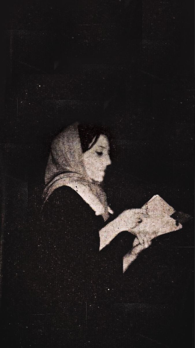 a woman reading a book in the dark with her head turned to look like she's holding something