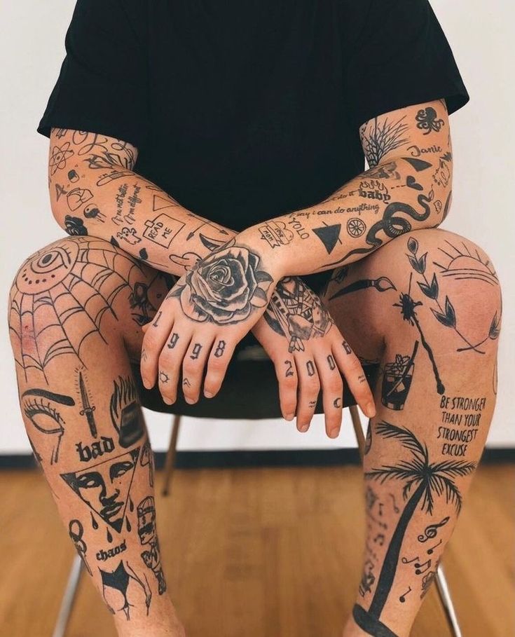 a man with lots of tattoos sitting on a chair