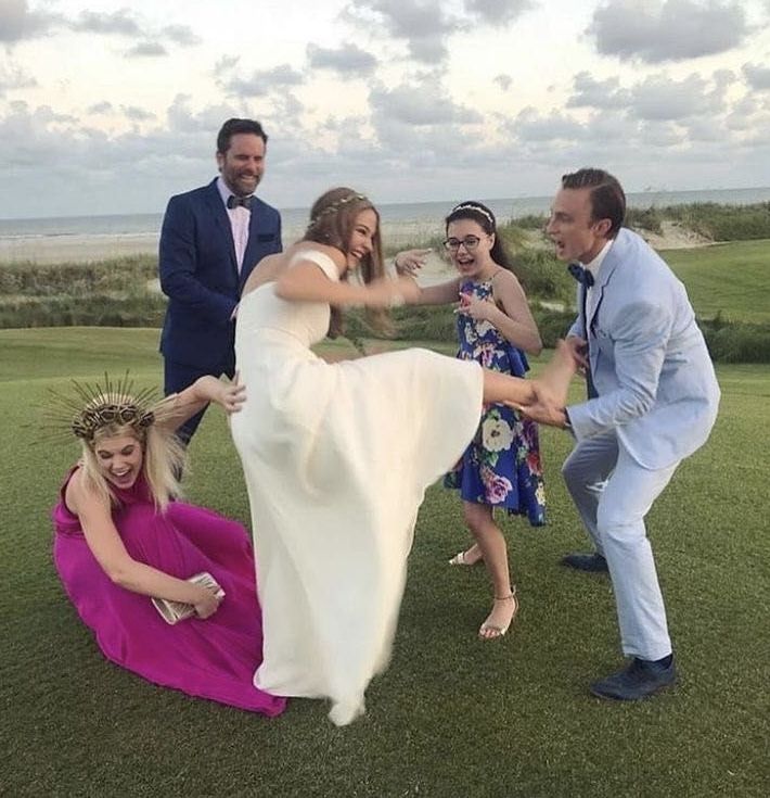 a group of people standing on top of a lush green field next to each other