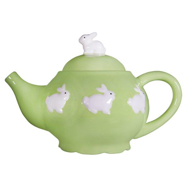 a green teapot with white rabbits on it