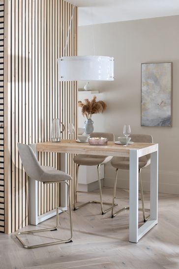 a dining room table with two chairs and a vase on the table next to it