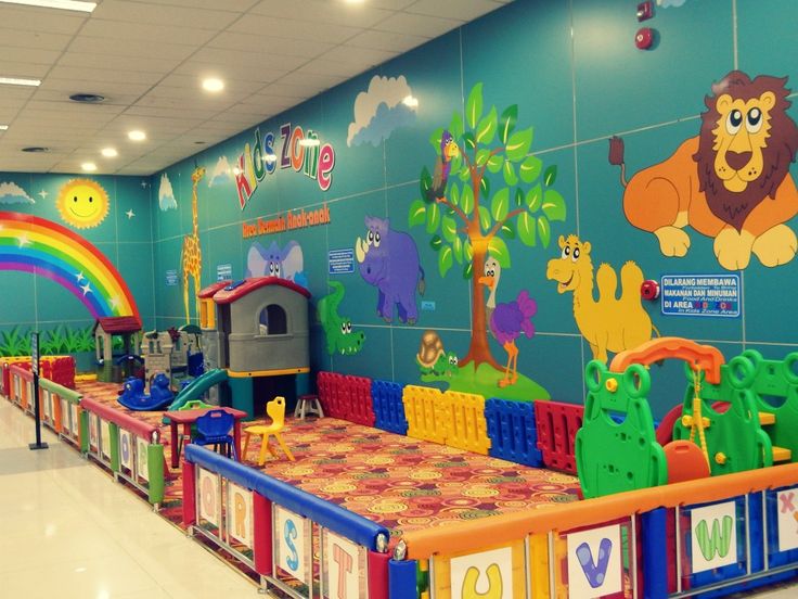 the children's play area is brightly decorated with animals and rainbows on the walls