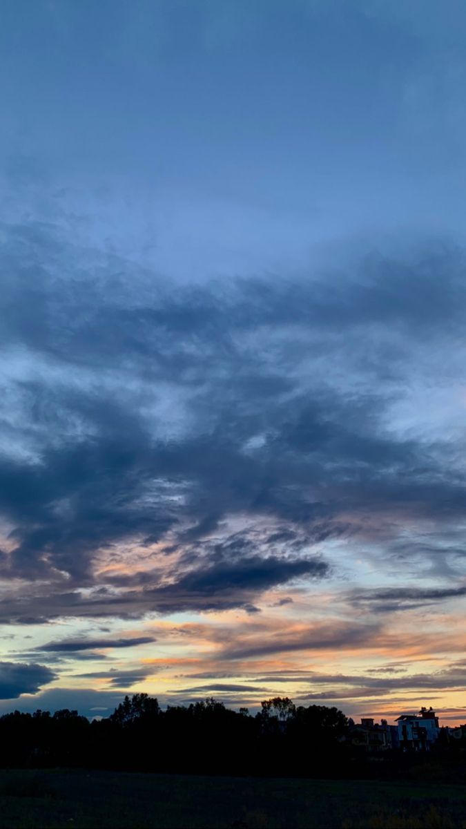 an airplane is flying in the sky at sunset