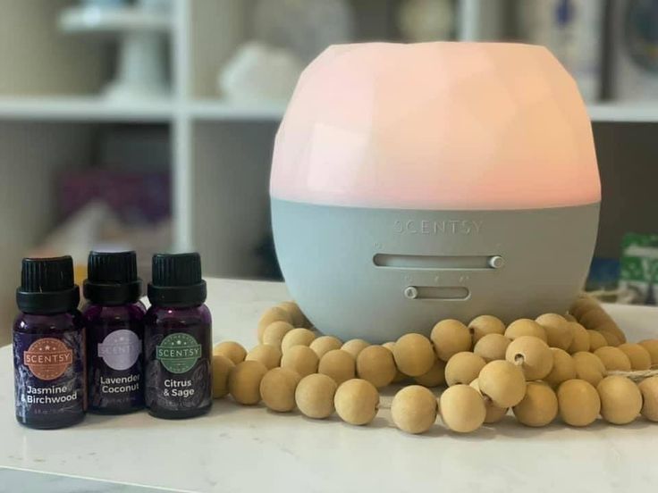 an air humider sitting on top of a counter next to bottles of essential oils