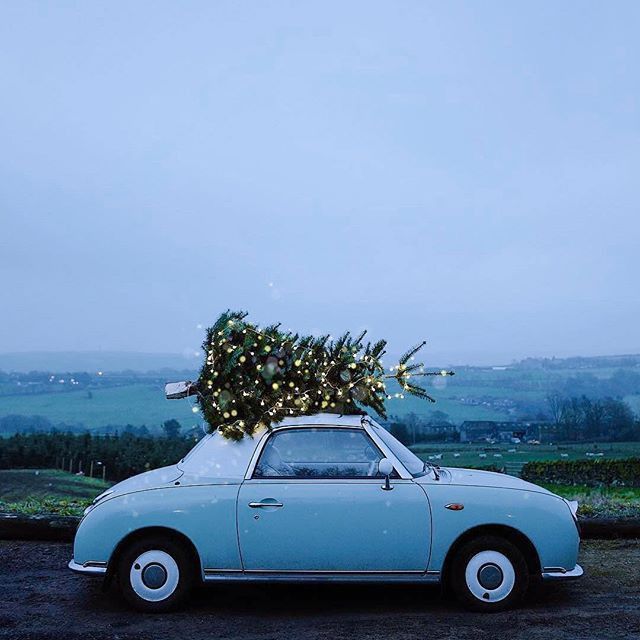 an old car with a christmas tree on top