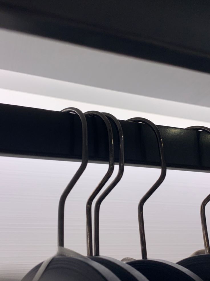 some black and white chairs hanging from a rail in a room with no one on it