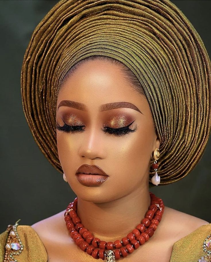 an african woman wearing a red necklace and matching earrings with her hair in a bun