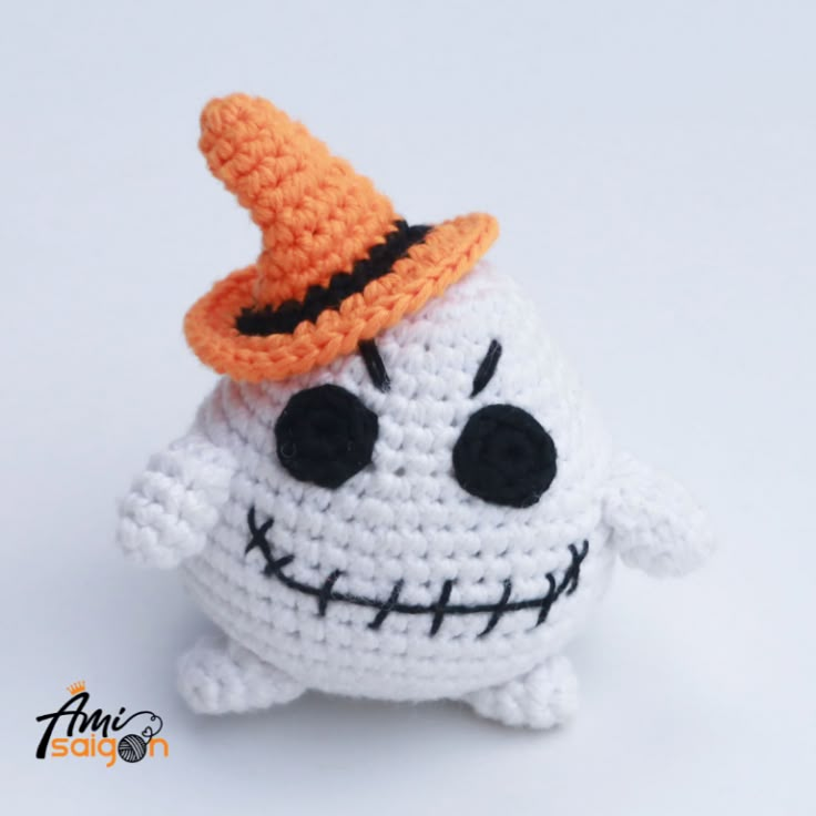 a small crocheted toy with a hat on it's head and eyes