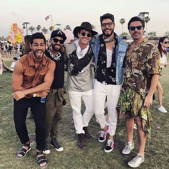 four men posing for the camera at an outdoor event