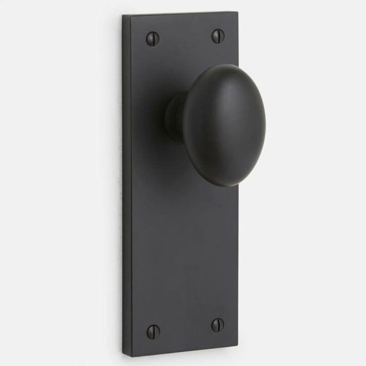 a black door handle with a round knob on the front and side of it, against a white background