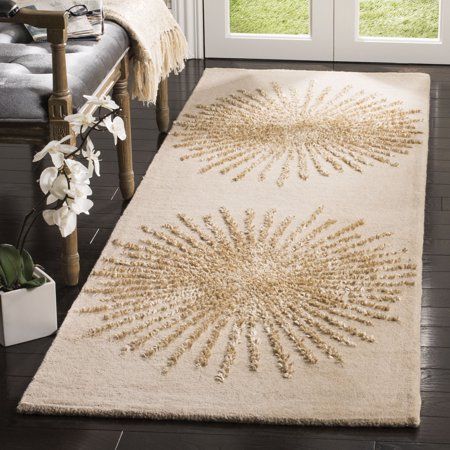 a white rug with an intricate design on the floor next to a chair and window