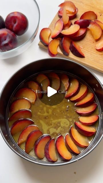 a pan filled with sliced peaches on top of a table next to a cutting board