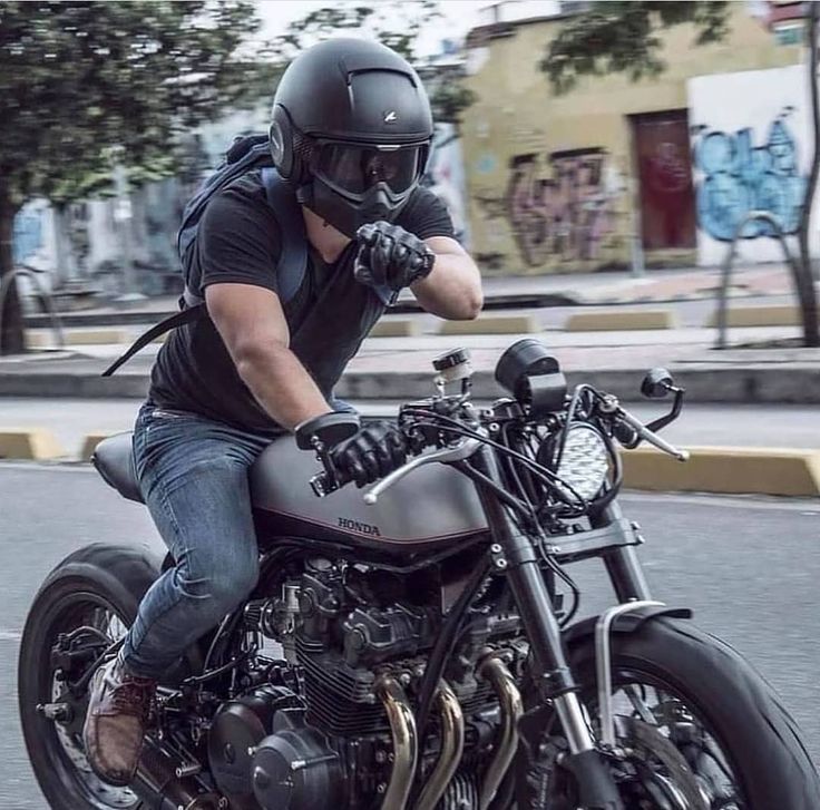 a man riding on the back of a motorcycle down a street