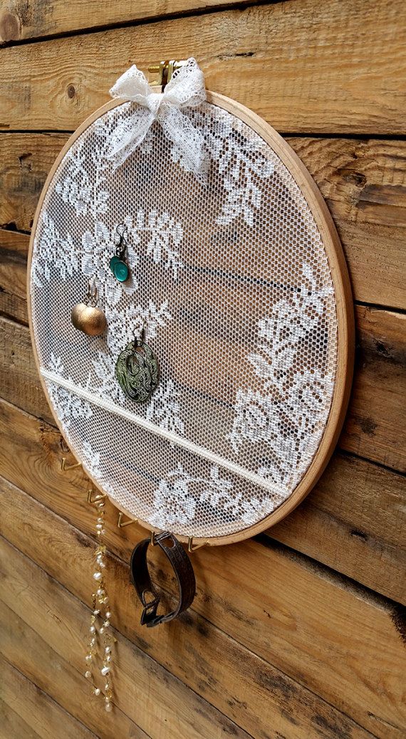 a white doily hanging on the side of a wooden wall with bells and beads