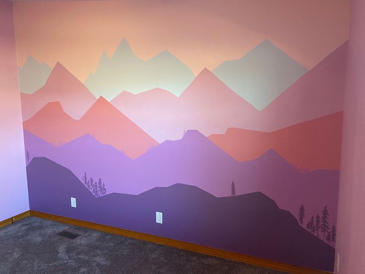 an empty room with mountains painted on the wall and carpeted flooring in front of it