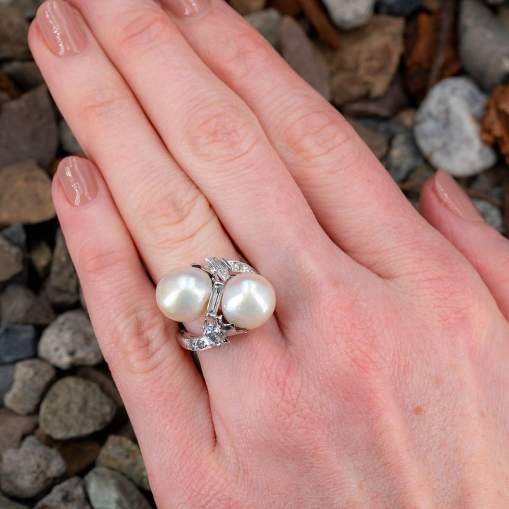 This magnificent vintage ring features a by-pass design and is accented with two (2), post set, cultured South Sea pearls, one (1), channel set, baguette cut diamond, one (1), prong set, half moon step cut diamond, one (1) trapezoid step cut diamond and four (4), bead set, round brilliant cut diamonds. The ring measures 17.6mm at the top, rises 11.5mm above the finger, tapering to 1.8mm wide and 1.2mm thick at the base of the shank. It is a size 6.25. The half-moon cut diamond has a small chip that cannot be seen without jewelers magnification. Elegant Multi-stone Diamond Wedding Ring, Elegant Polished Bypass Ring For Anniversary, Elegant Bypass Ring With Diamond Accents, Elegant Diamond White Bypass Ring For Anniversary, Elegant Wedding Bypass Ring With Diamond Accents, Elegant Diamond White Bypass Ring For Formal Occasions, Elegant Multi-stone Pear-shaped Diamond Ring, Elegant Multi-stone Diamond Anniversary Ring, Elegant Multi-stone Diamond Ring For Anniversary