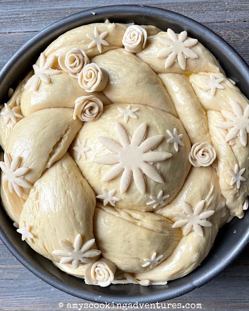 a cake with frosting and flowers on it in a pan, ready to be baked