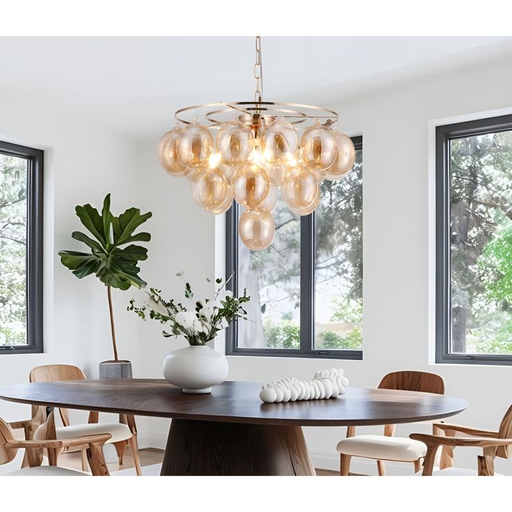 a dining room table with chairs and a potted plant in the center surrounded by windows