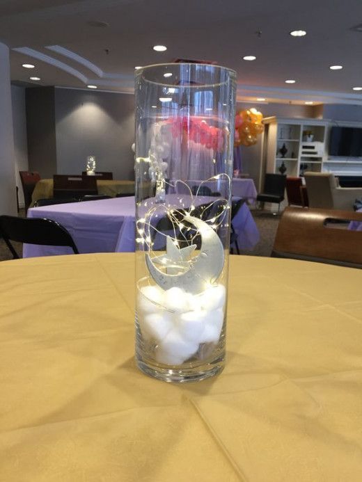 a vase filled with white rocks and water on top of a table in a room