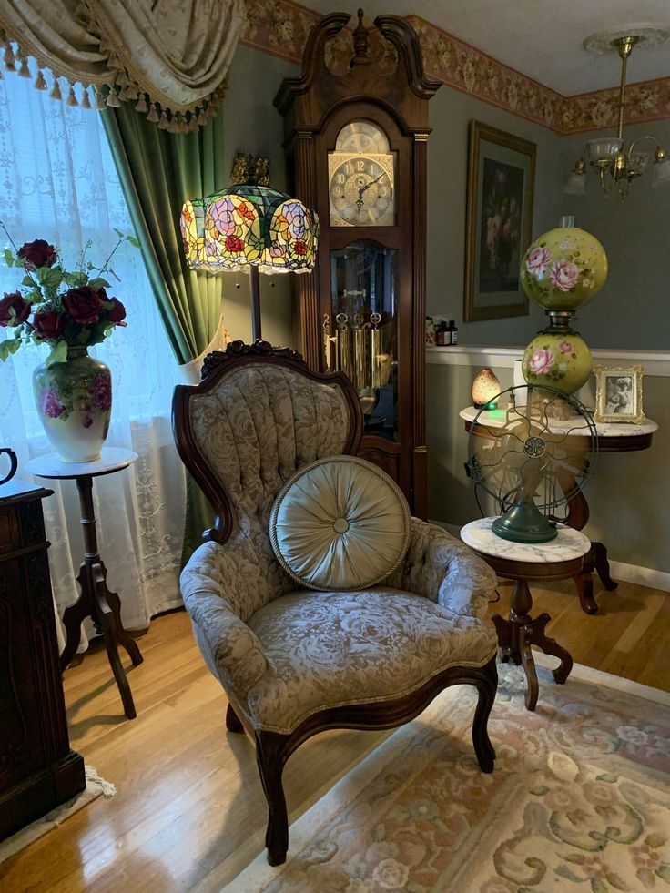 an ornate chair in the corner of a room with flowers and clocks on the wall