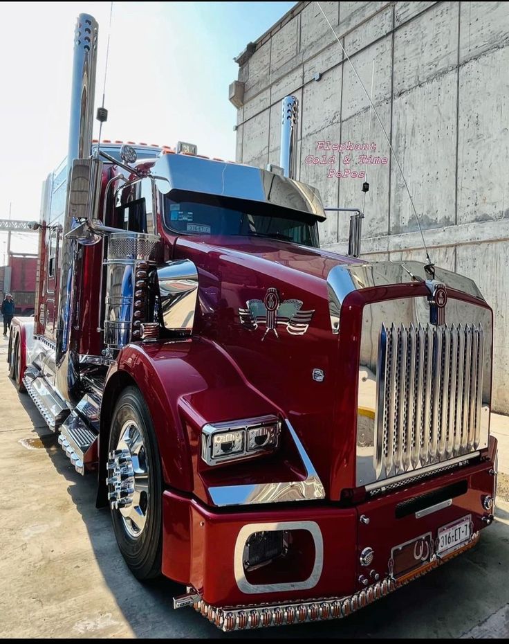 a red semi truck parked in front of a building