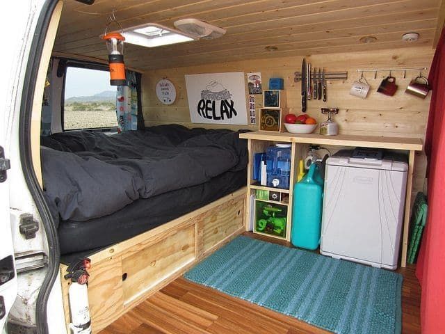 a bed in the back of a truck with shelves and drawers on it's side