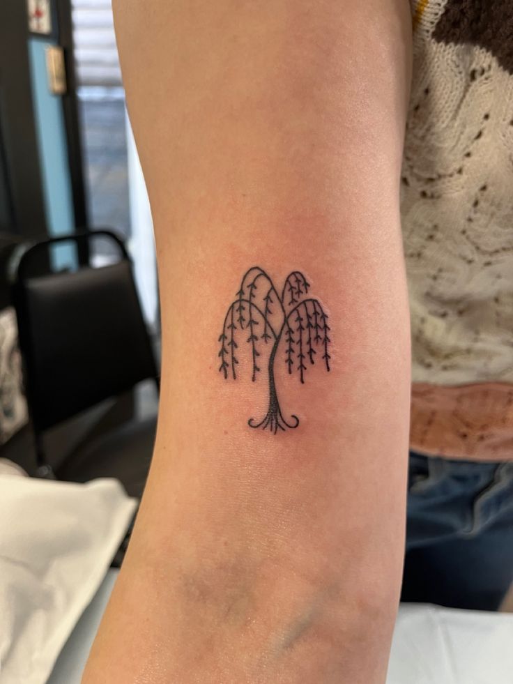 a small tree tattoo on the arm