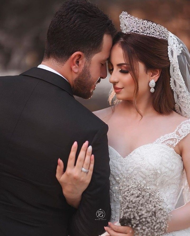 a bride and groom embracing each other in their wedding day attire at the same time