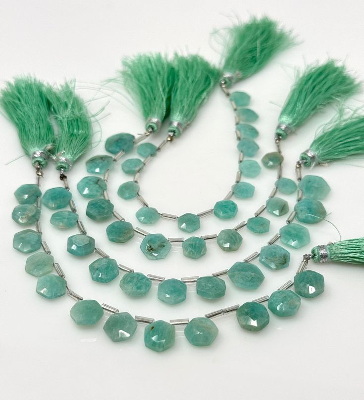 the necklace has green beads and tassels on it