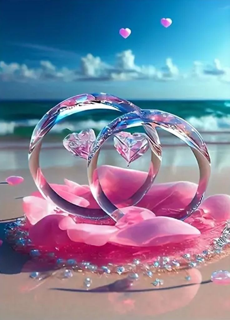 two wedding rings surrounded by pink petals on the beach with hearts floating in the air