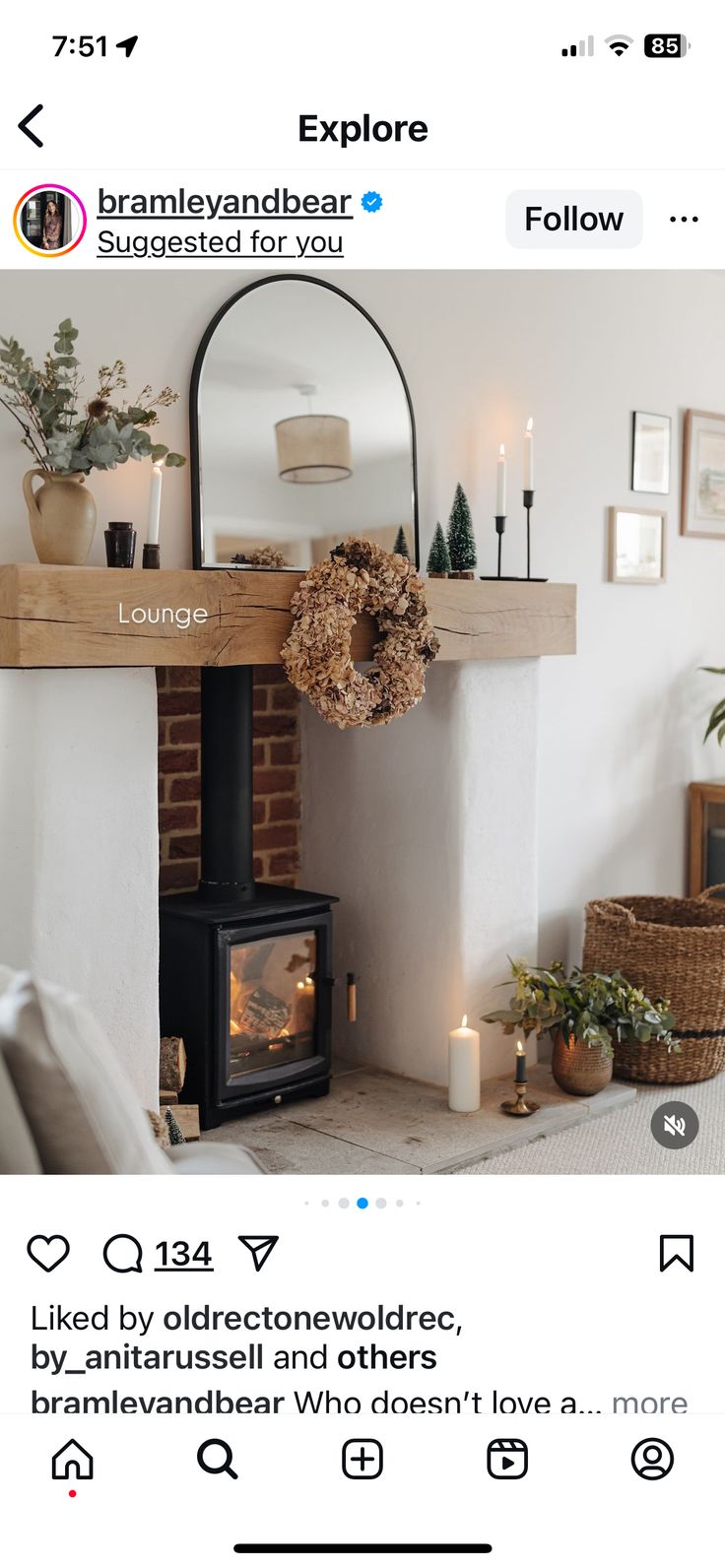 a fireplace with a mirror above it and candles on the mantle next to it,