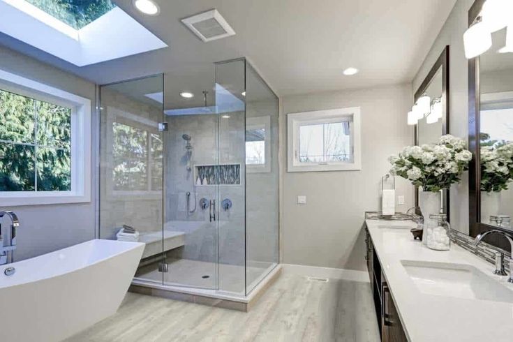 a large bathroom with a skylight above the bathtub and sink area, along with a walk in shower