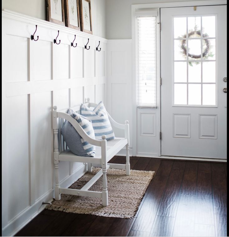 a white bench sitting in front of a door