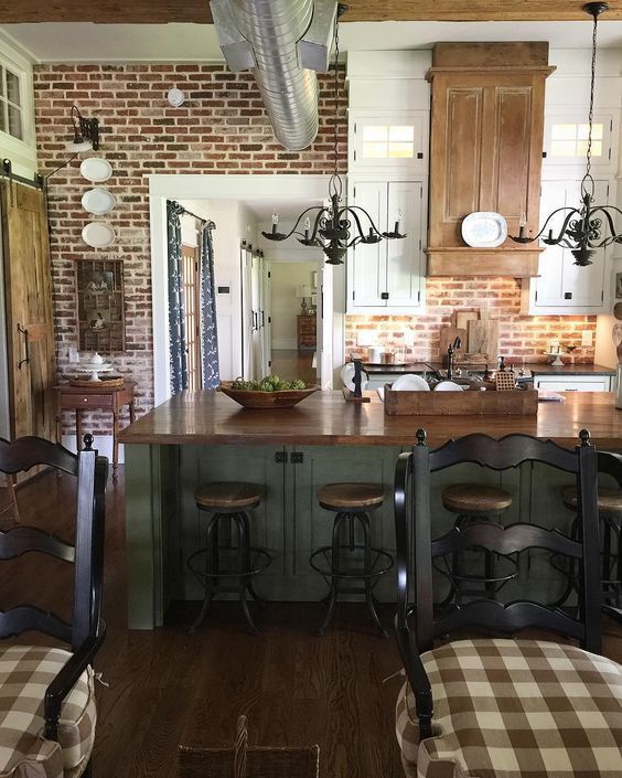 a kitchen with an island and stools in the center, surrounded by wooden flooring